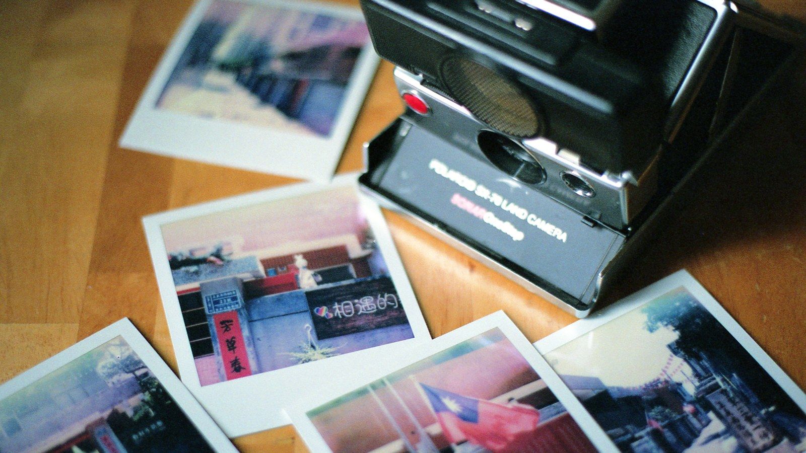 A real Polaroid SX-70 instant camera with printed photos, not the Pokémon-themed edition specifically