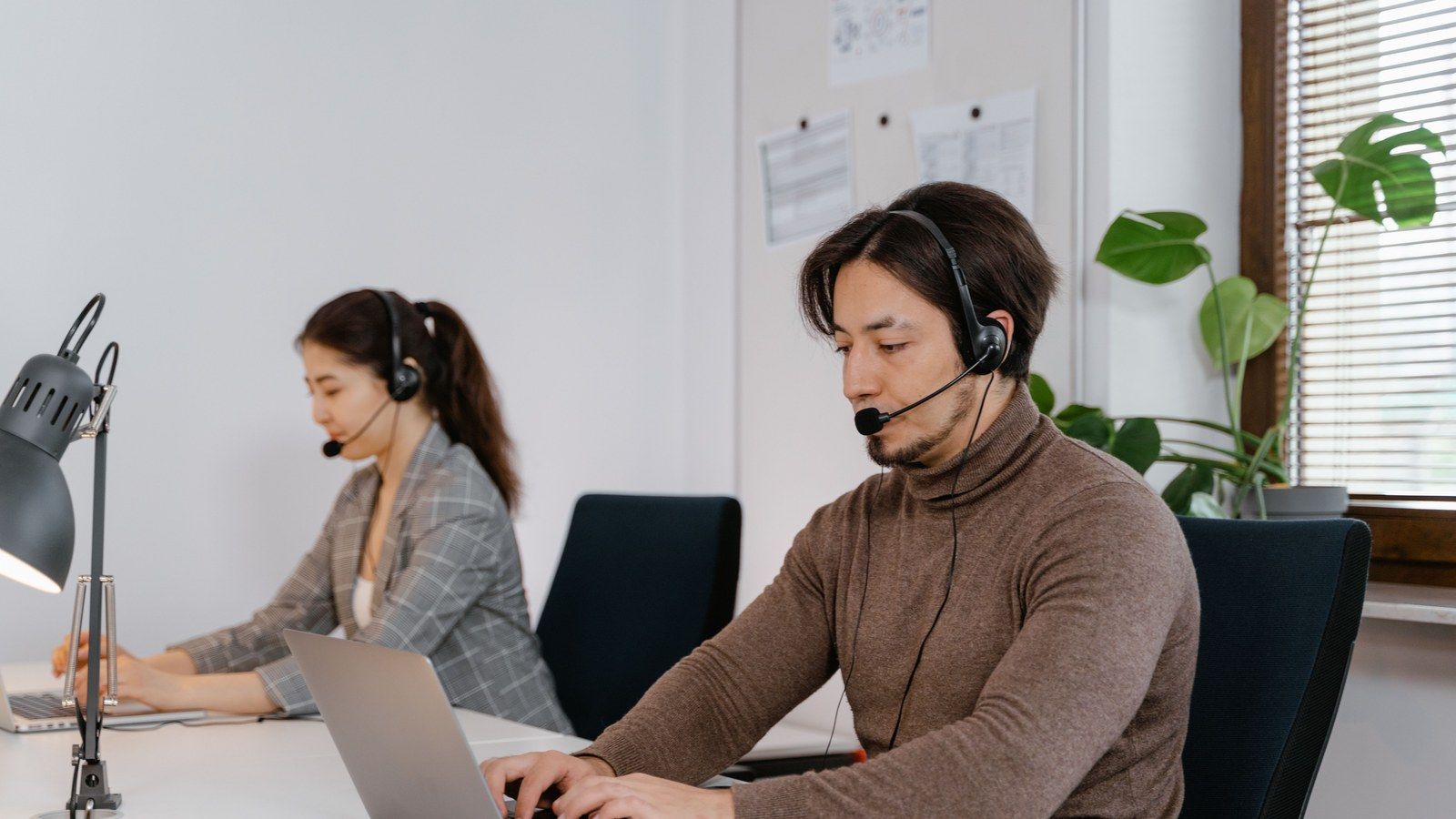 Stock photo of a person using a laptop while wearing a headset, illustrative only, not Wispr Flow's actual product