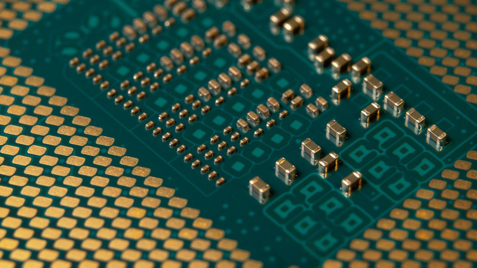 Stock photo of a microprocessor circuit board with gold contacts and surface-mount components, not Etched's actual hardware